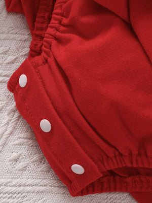 Red cotton baby romper with white snaps and ruffled elastic waist detail