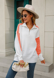 Colorblock zip-neck knit pullover sweater in white with orange sleeves and side panels.