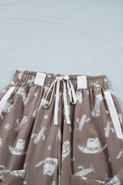 Brown cotton joggers with white western print, drawstring waist, and white side stripe details.