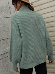Green ribbed knit turtleneck sweater with voluminous balloon sleeves.