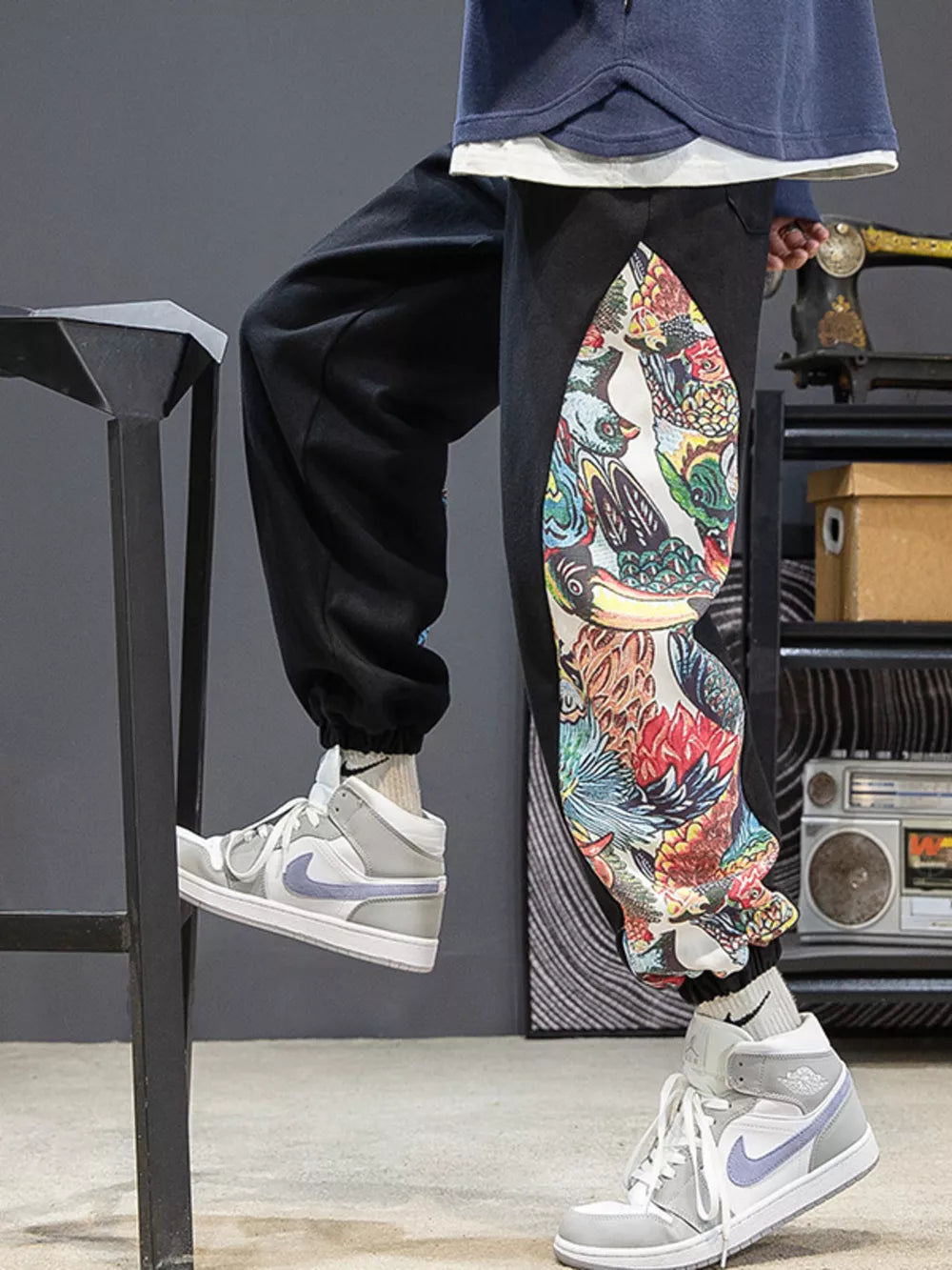 Black joggers with a vibrant, colorful side panel print and elastic cuffs.