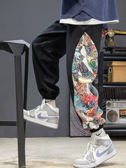 Black joggers with a vibrant, colorful side panel print and elastic cuffs.