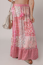 Printed tiered maxi skirt in dusty pink with tassel detail and boho pattern.