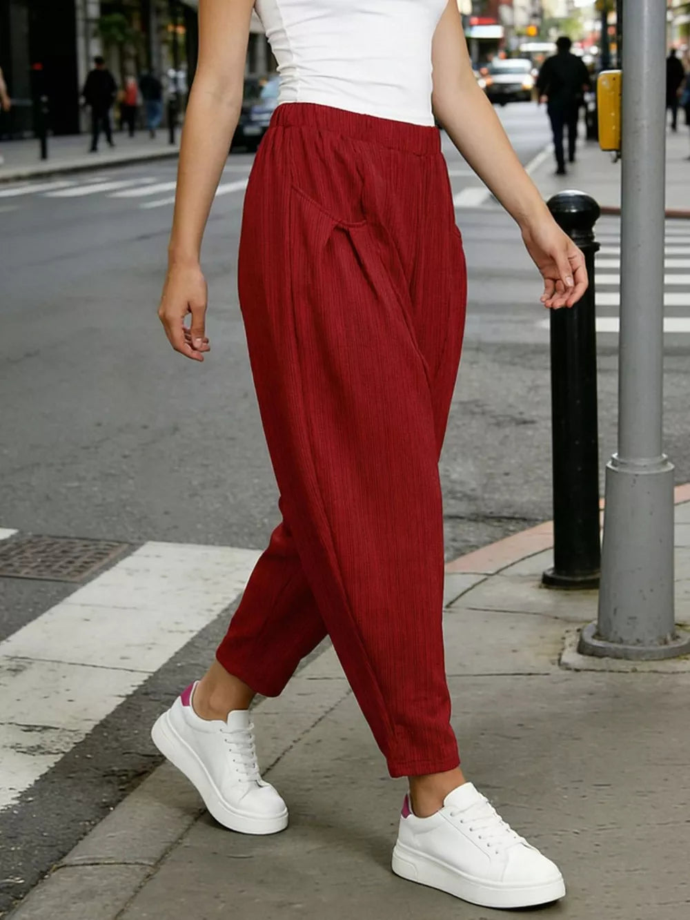 Burgundy harem pants with pockets and subtle vertical ribbing, worn with white sneakers.