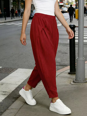 Burgundy harem pants with pockets and subtle vertical ribbing, worn with white sneakers.