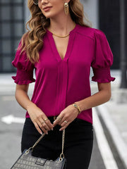 Sophisticated notched blouse in Cerise with puffed sleeves and smocked cuffs.