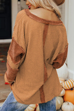 Caramel waffle knit henley top with contrast stitching and raw hem details.