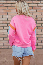 Colorblock sleeve crewneck sweatshirt in fuchsia pink with blue and orange accents.