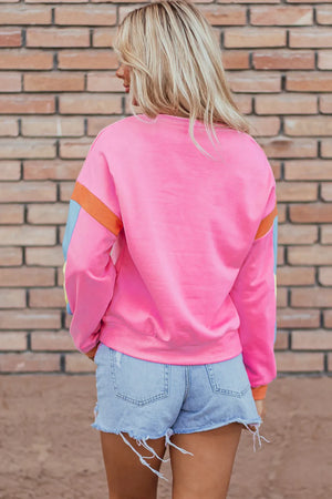 Colorblock sleeve crewneck sweatshirt in fuchsia pink with blue and orange accents.