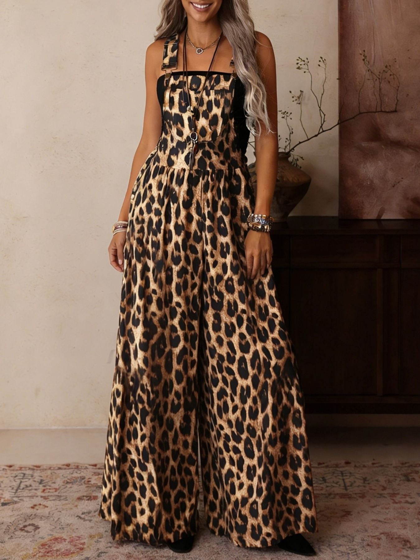 Leopard print wide leg romper with adjustable straps and buckle hardware.