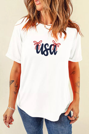 White cotton t-shirt with navy blue USA graphic and red embroidered bows.