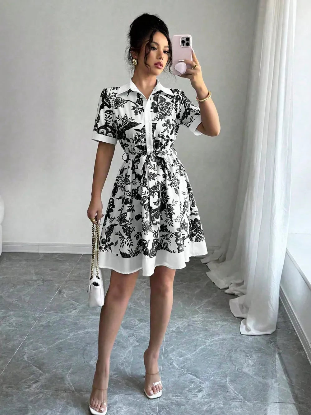 Black floral print mini dress with short sleeves, collar, and tie belt.