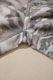 Maternity pants with a grey and beige camo print and reinforced seams.