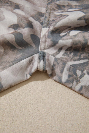 Maternity pants with a grey and beige camo print and reinforced seams.