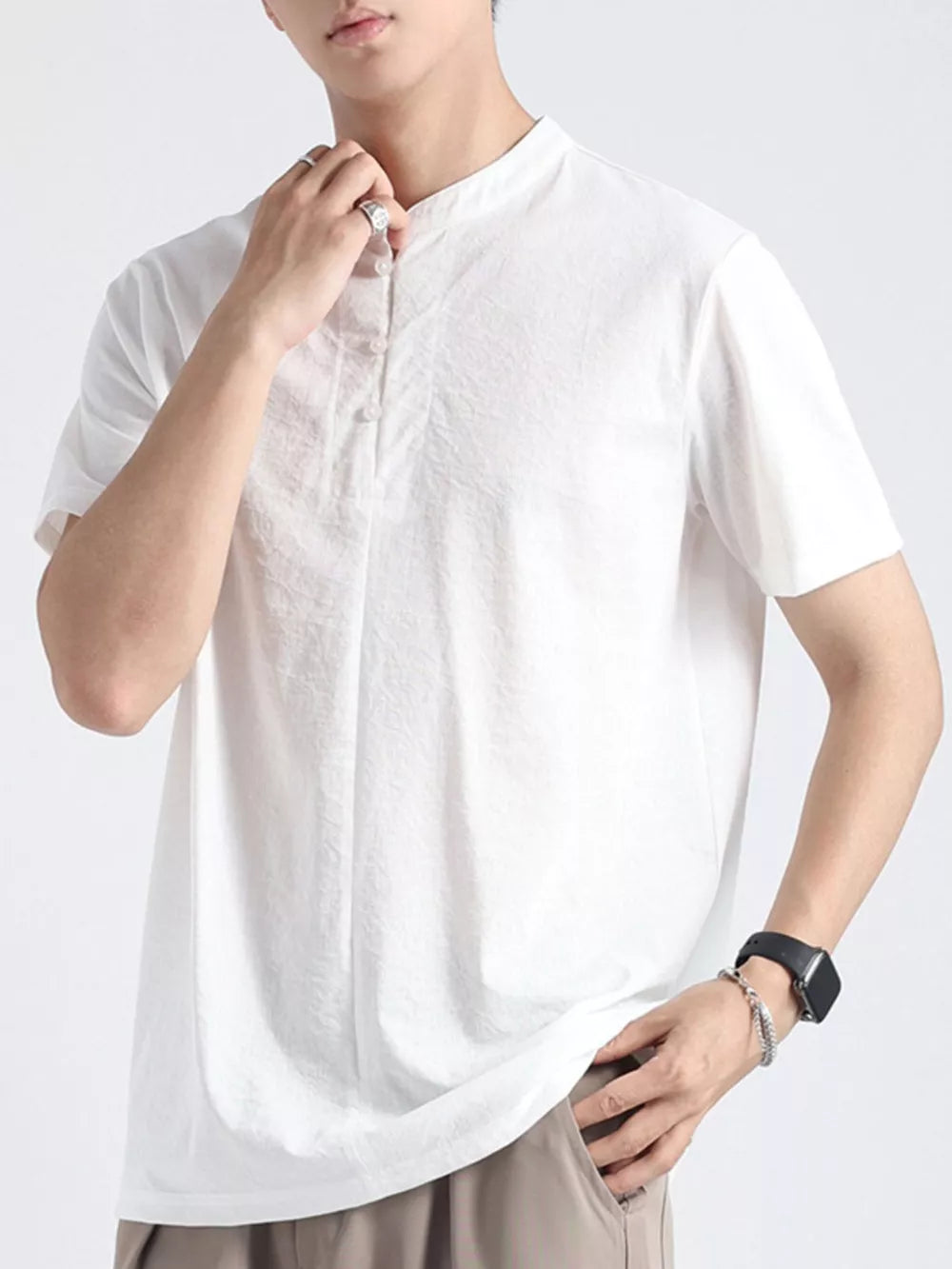 Men's white buttoned henley t-shirt with band collar and short sleeves.