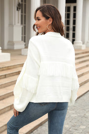 White acrylic cardigan with fringe detail on sleeves and back, featuring a relaxed fit.
