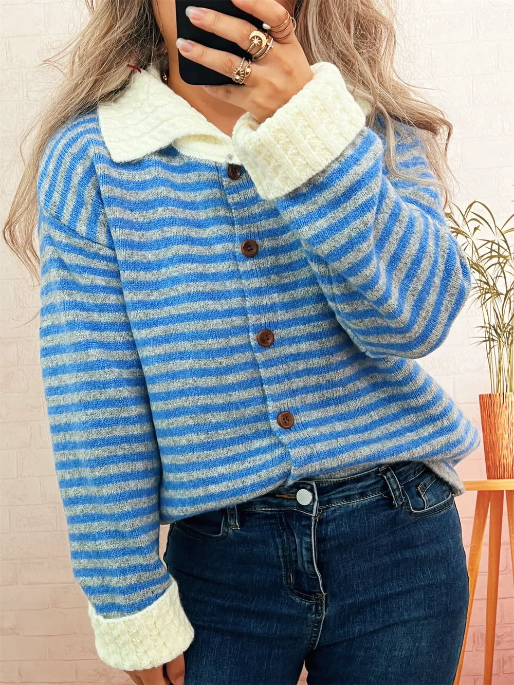 Blue striped knit cardigan with textured collar and cream cuffs, button-down front.
