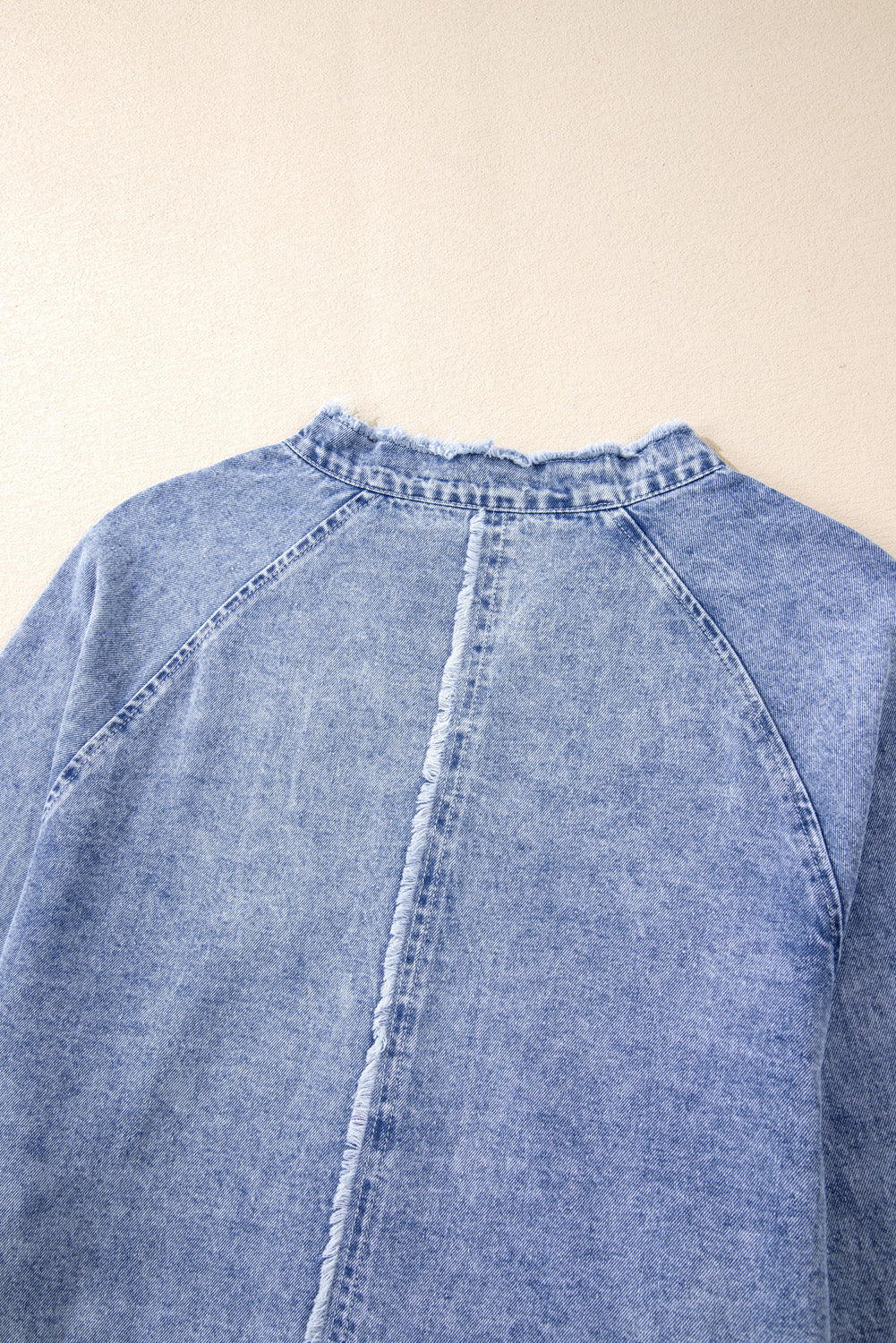 Acid wash denim shirtdress with raw hem neckline and frayed back seam detail.
