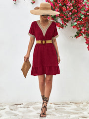 Burgundy A-line dress with Swiss dots, V-neck, crochet trim, and ruffled hem.