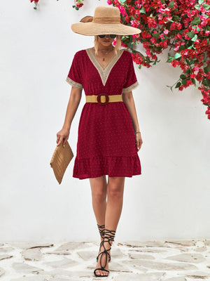 Burgundy A-line dress with Swiss dots, V-neck, crochet trim, and ruffled hem.