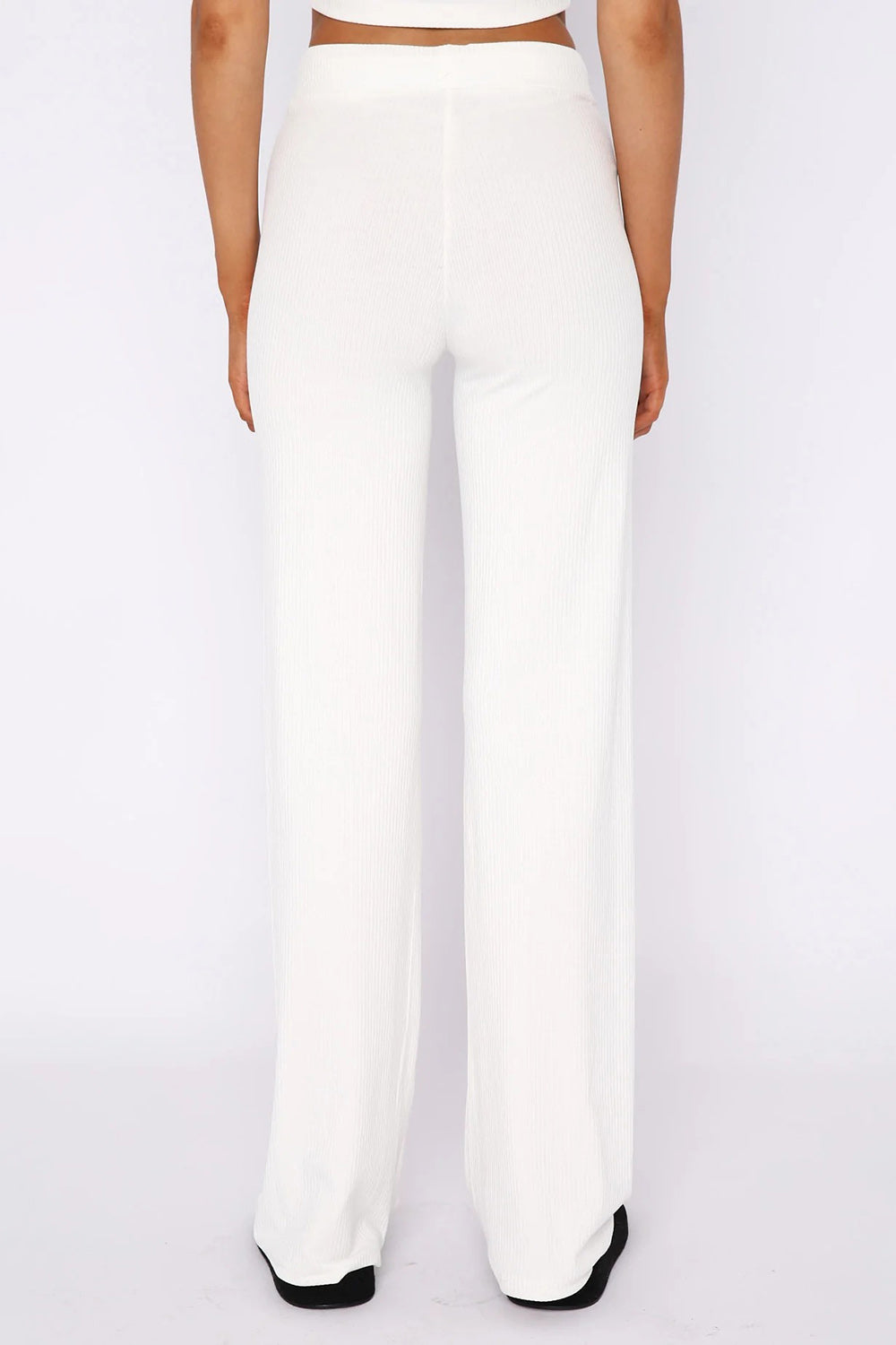White ribbed wide leg pants with a high waist, shown from the back.