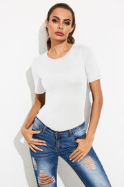 White crew-neck jersey bodysuit with short sleeves, styled with ripped jeans.