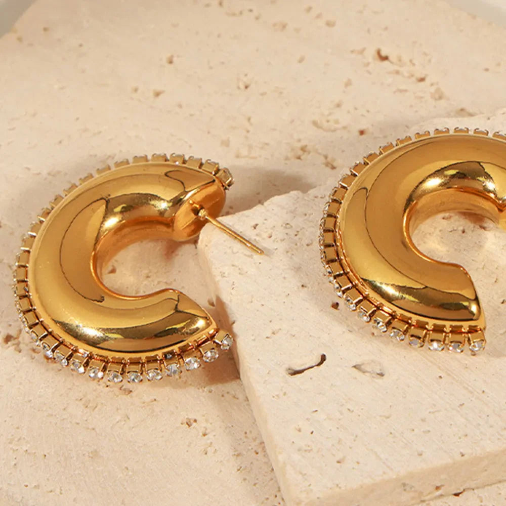 Gold cubic zirconia embellished crescent hoop earrings with a celestial design.
