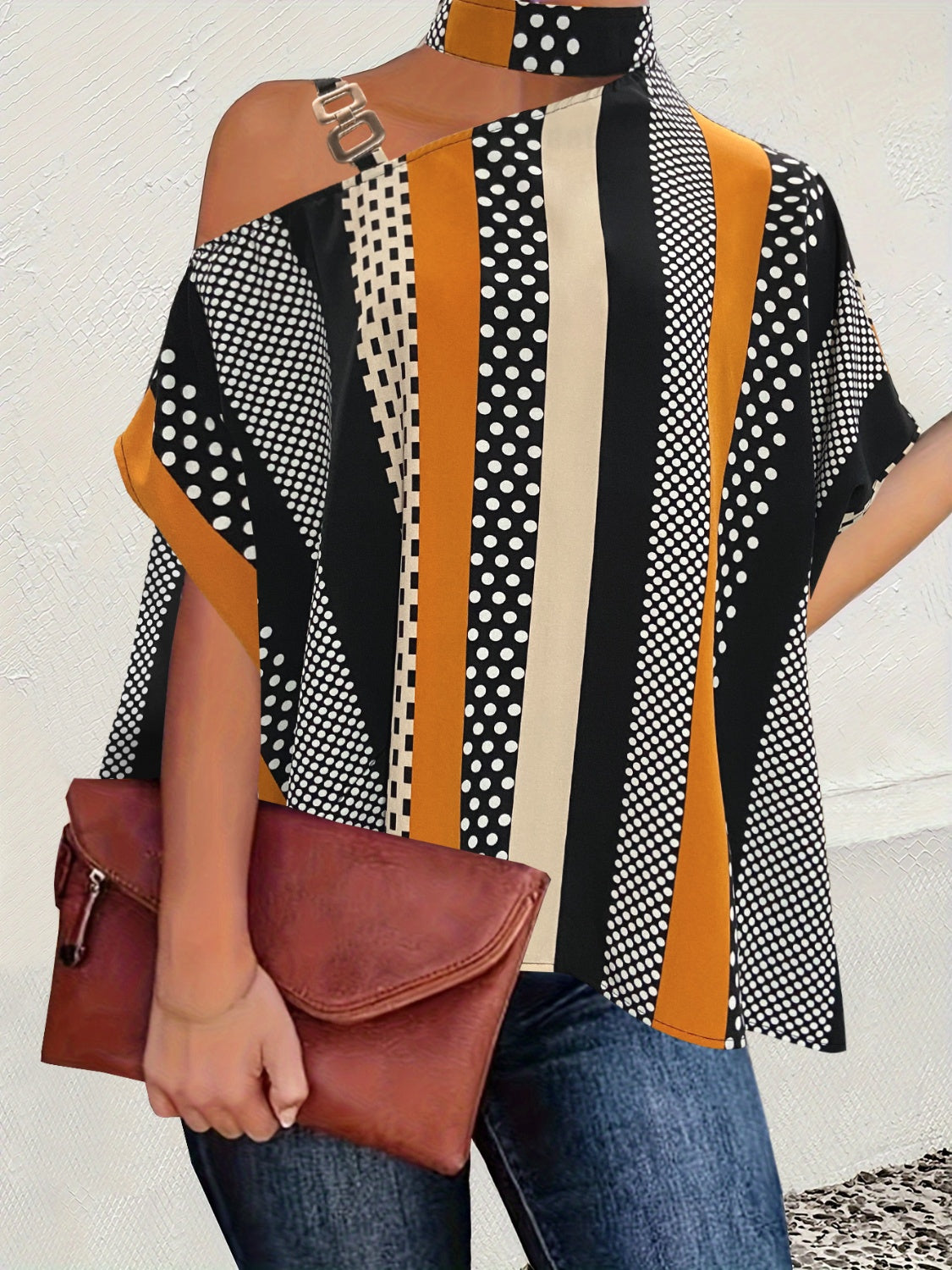 Asymmetric stripe shoulder top in black with gold hardware and mixed patterns.