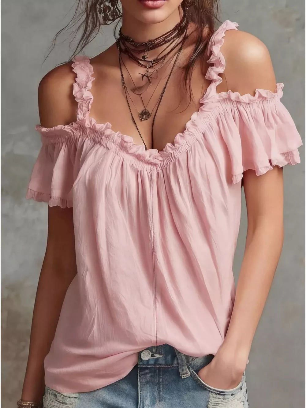 Pink ruffled cold shoulder shirt with deep V-neck and short sleeves.