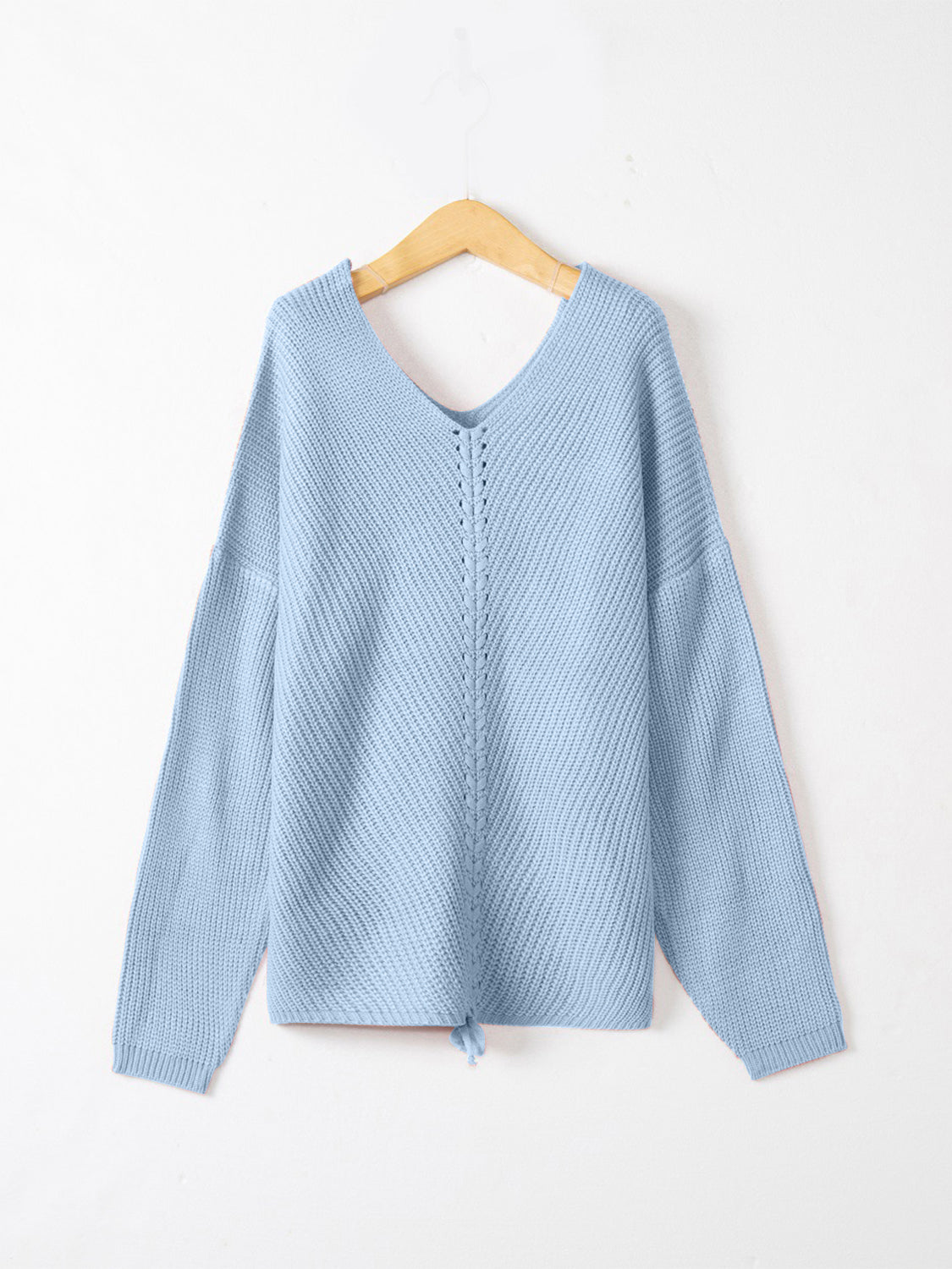 Pastel blue slouchy knit sweater with V-neck and lace-up detail at hem