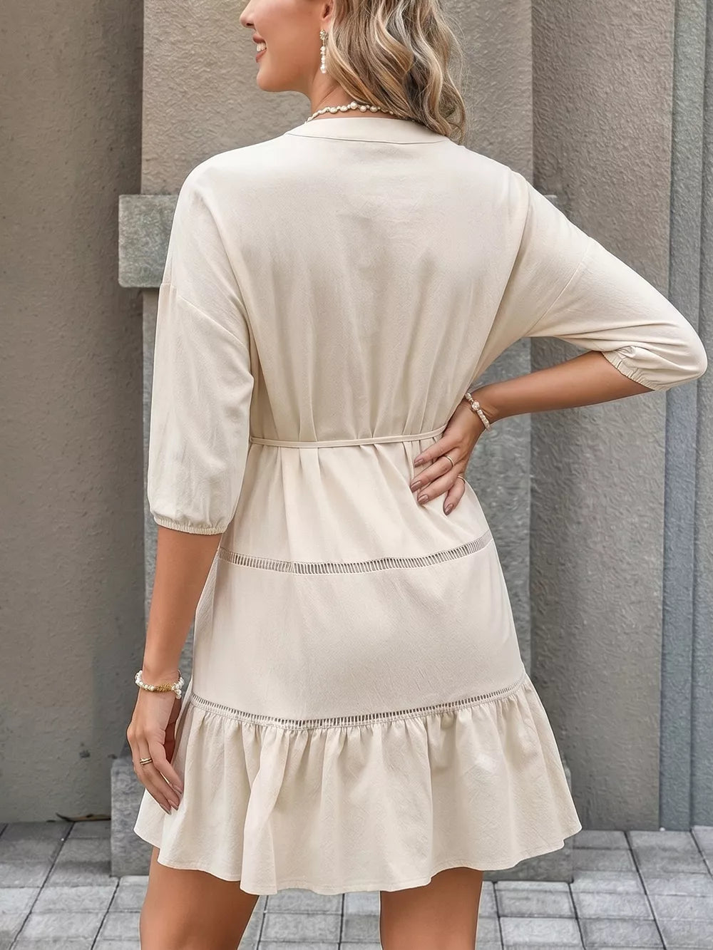 Apricot cotton V-neck mini dress with button details, tiered ruffles, and a cinched waist.