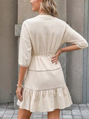 Apricot cotton V-neck mini dress with button details, tiered ruffles, and a cinched waist.