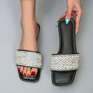 Black open toe slide sandals with pearl and rhinestone embellished straps.