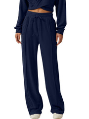 Dark blue relaxed fit pants with drawstring waist and front seam detail.
