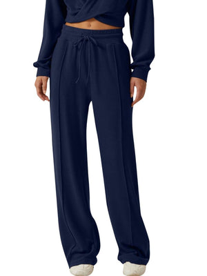 Dark blue relaxed fit pants with drawstring waist and front seam detail.
