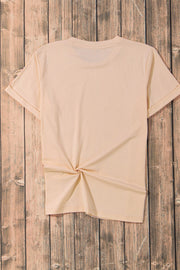 Tan t-shirt with rolled sleeves and a knotted hem detail.