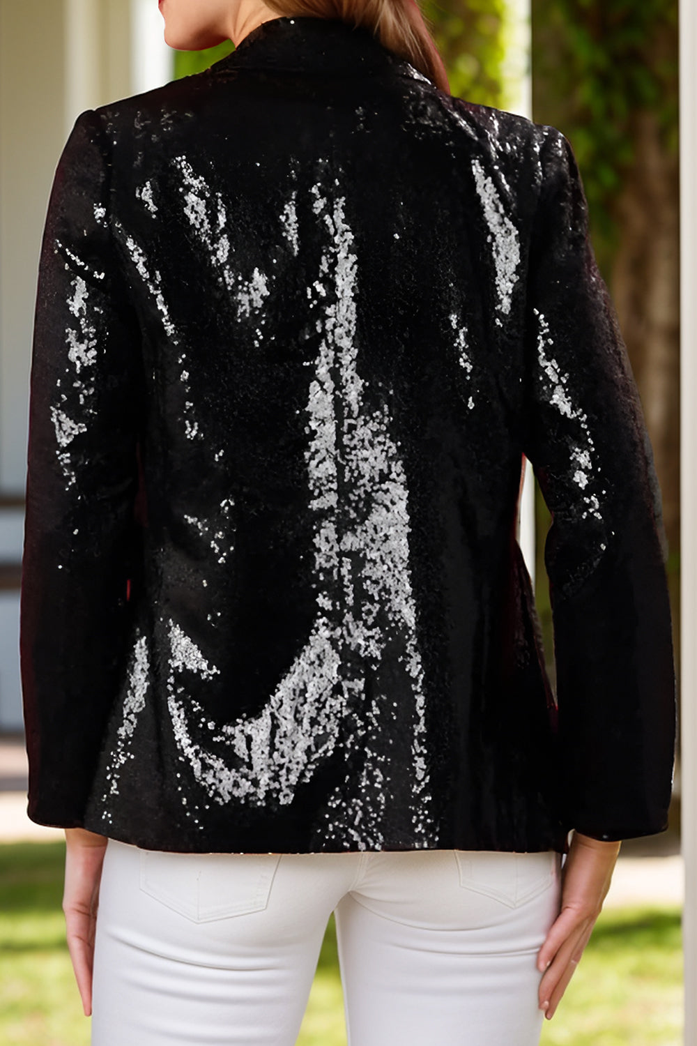 Black sequin blazer with nutcracker appliqué detail, buttoned front, and long sleeves.