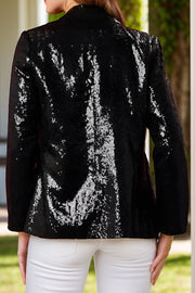 Black sequin blazer with nutcracker appliqué detail, buttoned front, and long sleeves.