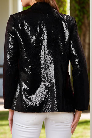 Black sequin blazer with nutcracker appliqué detail, buttoned front, and long sleeves.