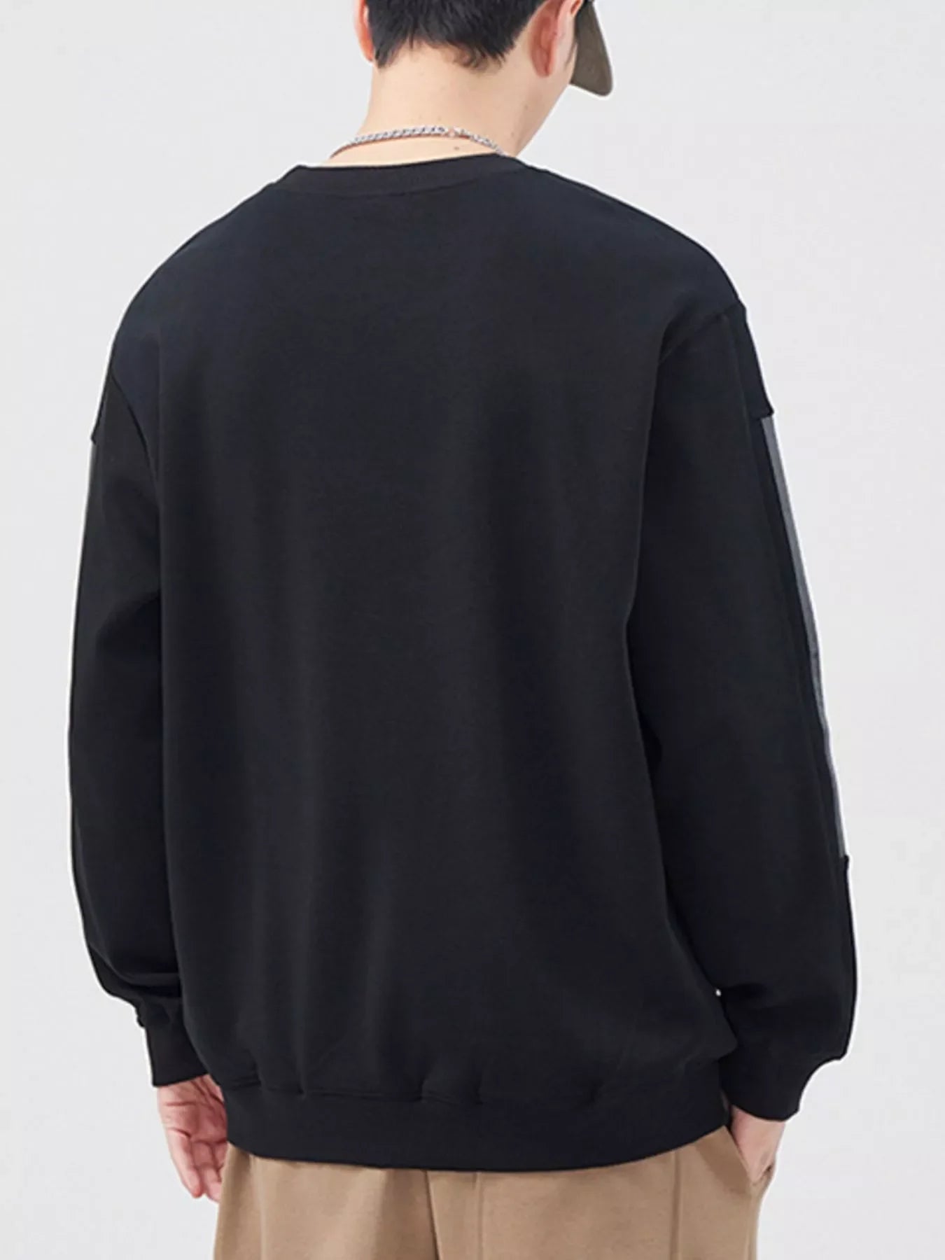 Black crewneck sweatshirt with contrasting stripe detail on sleeves