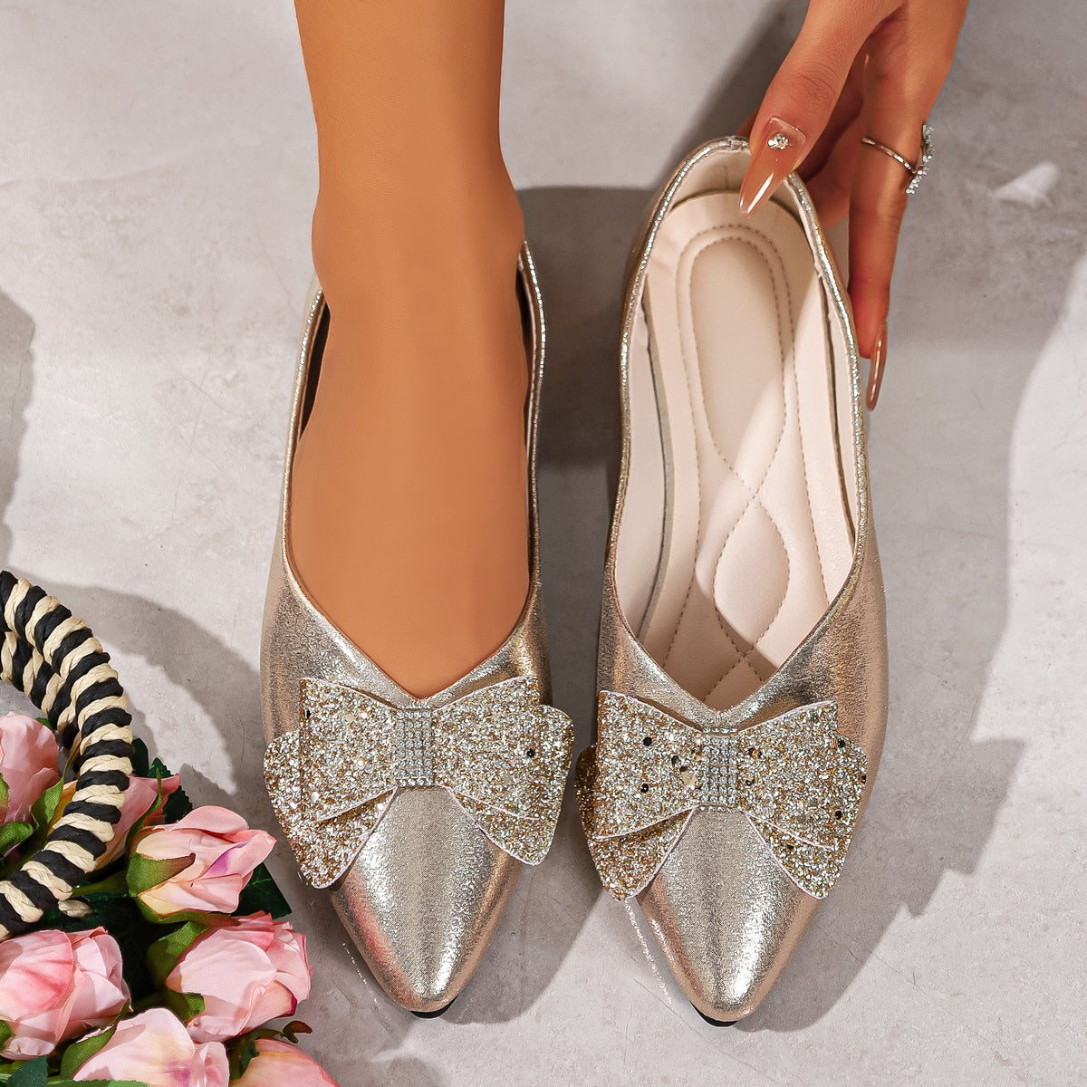 Gold pointed toe flats with dazzling crystal bows.