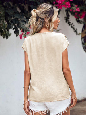 Beige Flutter V Blouse with textured fabric and cap sleeves.