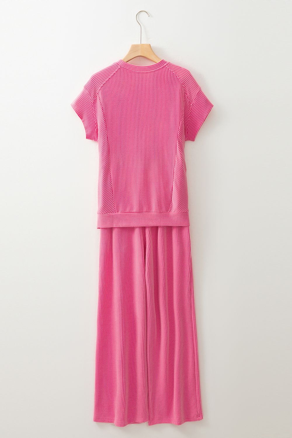 Fuchsia pink ribbed knit drawstring co-ord set with short sleeves and wide-leg pants.
