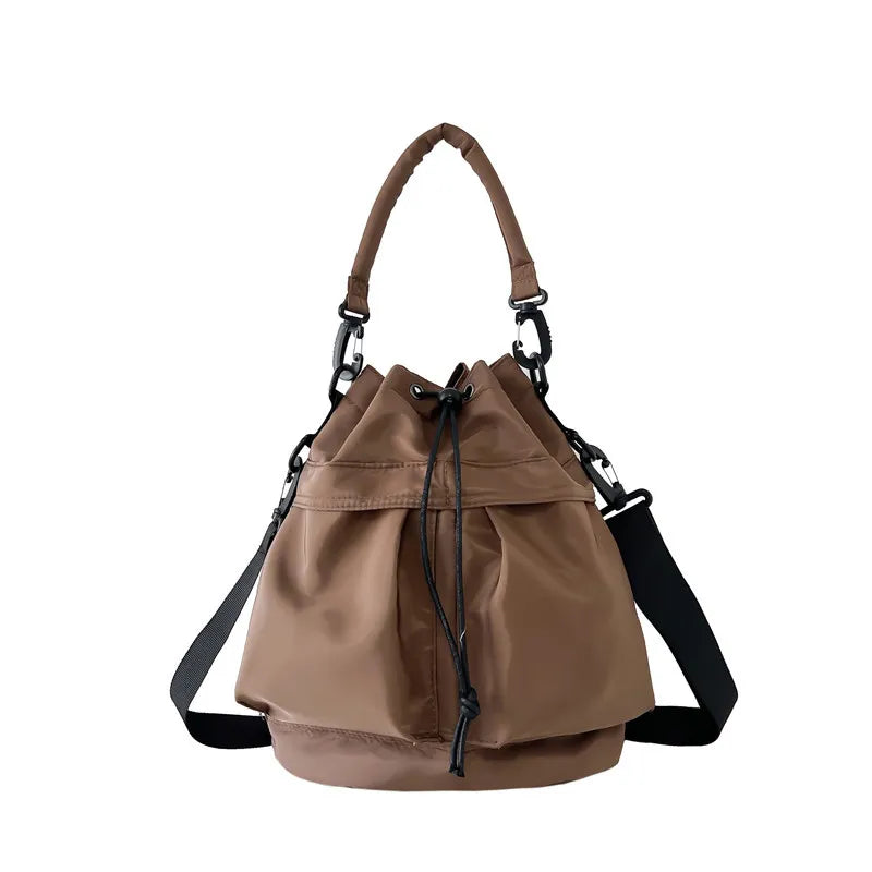 Brown nylon drawstring bucket bag with top handle and crossbody strap