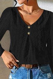 Black textured diamond-stitch button-down blouse with V-neck and two buttons.