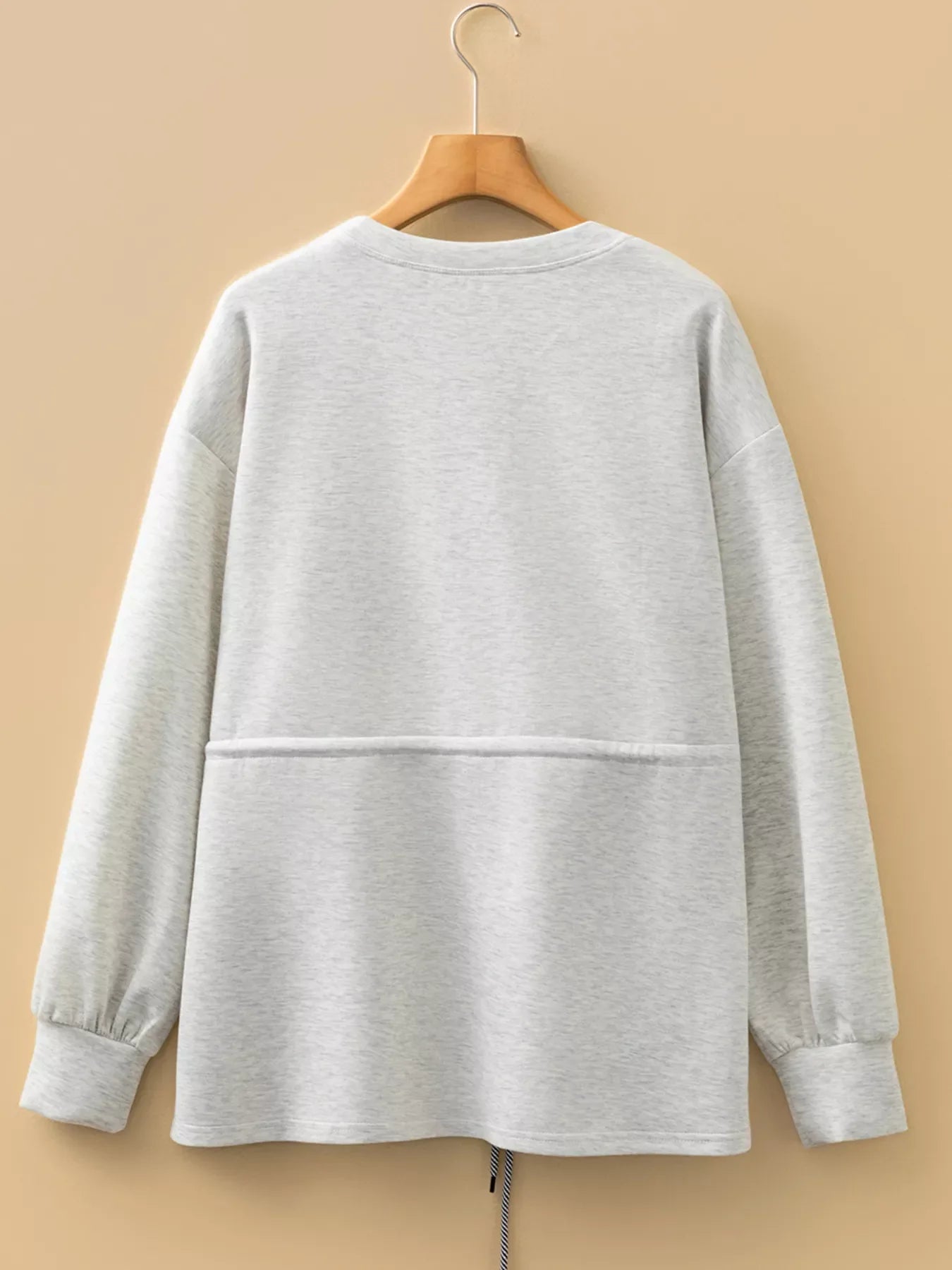 Light gray tunic sweatshirt with drawstring waist and gathered cuffs.