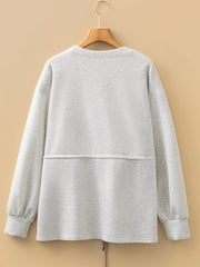 Light gray tunic sweatshirt with drawstring waist and gathered cuffs.