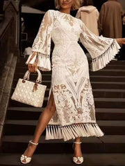 White lace midi dress with bell sleeves, tassel hem, and side slit.