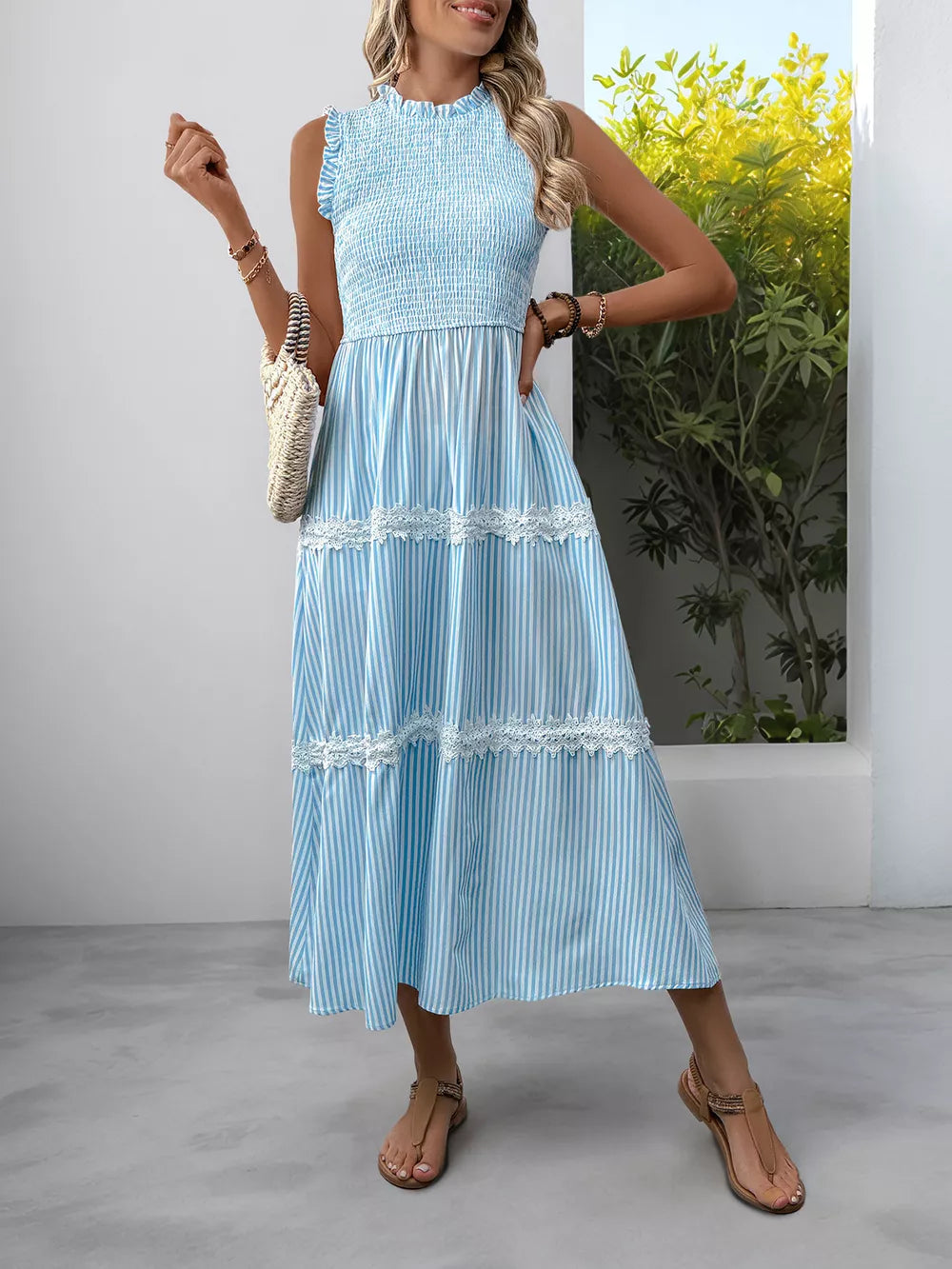 Blue striped sleeveless midi dress with smocked bodice and lace trim tiers.