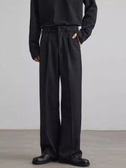Black pleated wide-leg trousers with a relaxed fit and side pockets.
